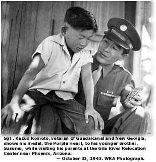 Sgt. Kazuo Komoto shows hist Purple Heart to his brother, Susumu Komoto at the Gila River Relocation Center